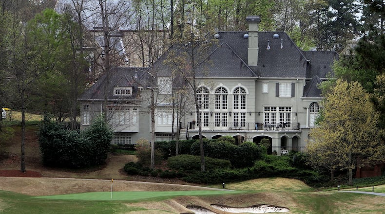 A huge home sits next to a green on the golf course at the Country Club of the South in Johns Creek. AJC FILE PHOTO