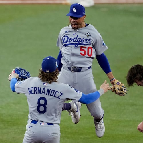 Los Angeles Dodgers' Mookie Betts (50) leaps into the arms of Kiké Hernández (8) after Toronto Blue Jays' Addison Barger, right, was forced out to end Game 6 of baseball's World Series, Friday, Oct. 31, 2025, in Toronto. (AP Photo/Ashley Landis)