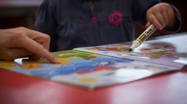 A young girl draws at child care center. (Photo by Matt Cardy/Getty Images)