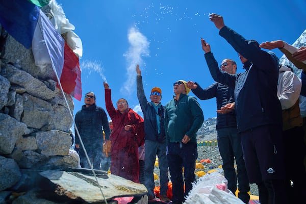 Kami Rita Sherpa, third left, who holds the record for most ascents to Mount Everest, prays with other mountaineers at Everest Base Camp before beginning his ascent to the summit of Mount Everest in Nepal, April 24, 2025. (AP Photo/Pasang Rinzee Sherpa)