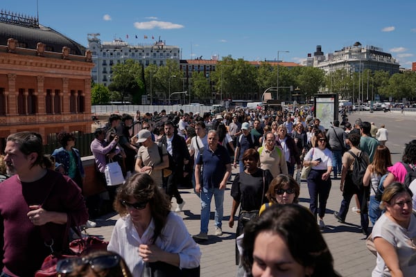 People walk outside Atocha train station during a nationwide power outage in Madrid, Monday, April 28, 2025. (AP Photo/Manu Fernandez)