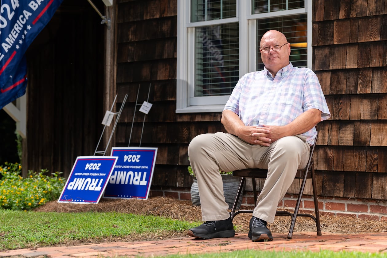 The Rev. Brant Kennedy, the first vice chair of the Washington County Republican Party, poses for a portrait in front of his home in Sandersville. Trump signs lean on a wall for local Republicans to pick up. (Seeger Gray / AJC)