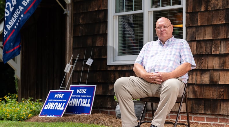The Rev. Brant Kennedy, the first vice chair of the Washington County Republican Party, poses for a portrait in front of his home in Sandersville. Trump signs lean on a wall for local Republicans to pick up. (Seeger Gray / AJC)