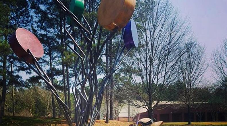 Craig Snyder installs his work, “Sweet Pops of Brilliance,” by the Eves Road entrance to East Roswell Park. ARTAROUND ROSWELL