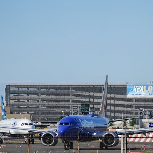 FILE - LaGuardia Airport's air traffic control tower, right, is shown as planes line-up for take-off, Thursday May 25, 2023, in New York. (AP Photo/Bebeto Matthews)