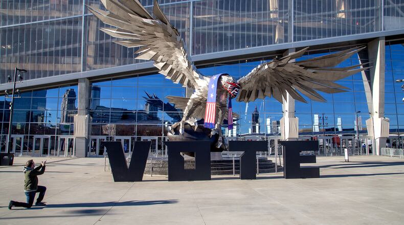 Philip Hourouras takes a photo of the falcon in front of the Mercedes-Benz Stadium on the first day of Early Voting at the Stadium Tuesday, December 22, 2020. STEVE SCHAEFER FOR THE ATLANTA JOURNAL-CONSTITUTION