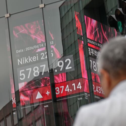 A person walks in front of an electronic stock board showing Japan's Nikkei index at a securities firm Tuesday, April 14, 2026, in Tokyo. (AP Photo/Eugene Hoshiko)