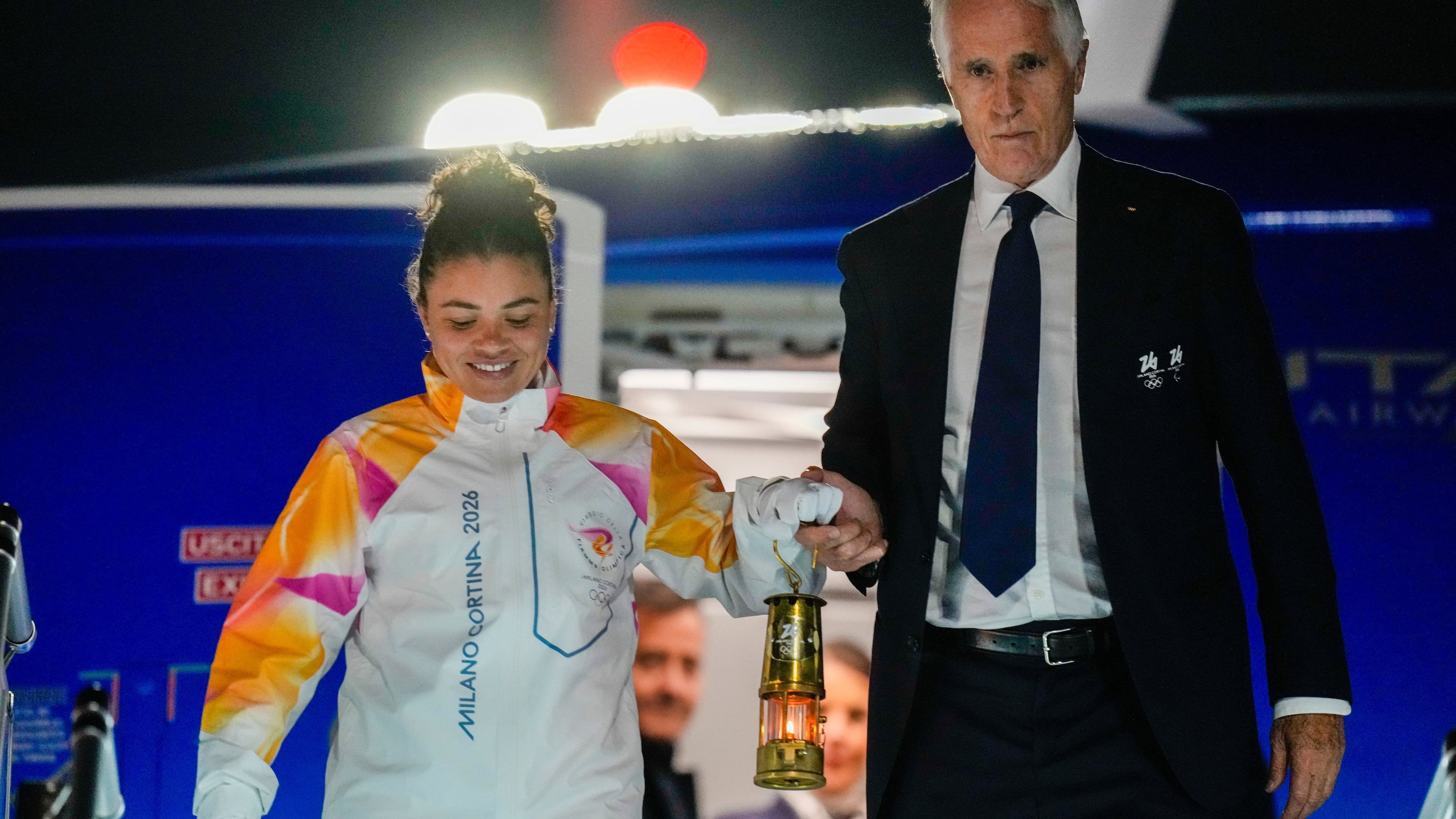 President of the Milano Cortina Organising Committee Giovanni Malago, right, and Italian Olympic medalist tennis player Jasmine Paolini hold a lantern with the Olympic flame as they arrive at Rome's International airport Leonardo da Vinci from Athens, Thursday, Dec. 4, 2025. (AP Photo/Gregorio Borgia)