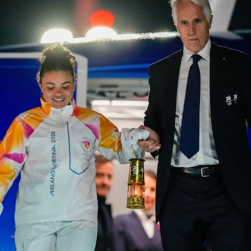 President of the Milano Cortina Organising Committee Giovanni Malago, right, and Italian Olympic medalist tennis player Jasmine Paolini hold a lantern with the Olympic flame as they arrive at Rome's International airport Leonardo da Vinci from Athens, Thursday, Dec. 4, 2025. (AP Photo/Gregorio Borgia)