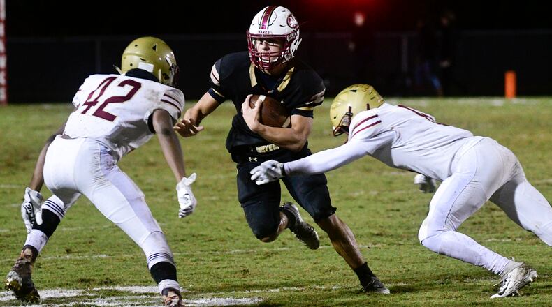 High school football state playoffs: Mill Creek running back Parker Wroble runs into the defense of Brookwood's Marquis Killebrew (42) and Dennarrio Stewart during the first half of Friday's game. (John Amis/Special)