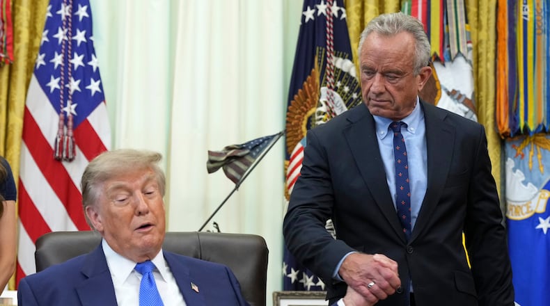 President Donald Trump, left, shakes the hand of Health and Human Services Secretary Robert F. Kennedy Jr. during a meeting to sign an executive order about vaccines, Monday, Aug. 10, 2026, in the Oval Office of the White House in Washington. (AP Photo/Jacquelyn Martin)