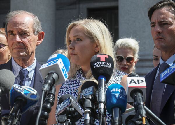 FILE - Virginia Giuffre, center, holds a news conference outside a Manhattan court in New York, Aug. 27, 2019. (AP Photo/Bebeto Matthews, File)