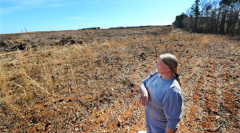 Property owner Ruth Wilson looks at a neighboring land whose owner dumps animal and waste sludge on fields to fertilize them outside Lexington, Wilson and her husband own Echo Hill, a non-working farm. They aand six others are suing the neighboring farmer over the smells and alleged hazards his practice creates. The General Assembly is considering legislation to limit such lawsuits. (Curtis Compton / Curtis.Compton@ajc.com)