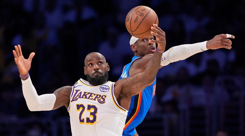 Los Angeles Lakers forward LeBron James, left, takes a pass as Oklahoma City Thunder guard Shai Gilgeous-Alexander defends during the first half of Game 3 in a second-round NBA basketball playoffs series Saturday, May 9, 2026, in Los Angeles. (AP Photo/Mark J. Terrill)