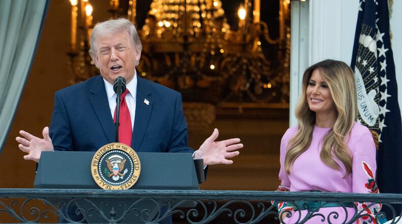 President Donald Trump with first lady Melania Trump addresses the attendees from the Blue Room Balcony of the White House during the annual Congressional Picnic on the South Lawn, Tuesday, May 19, 2026, in Washington. (AP Photo/Manuel Balce Ceneta)