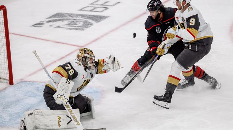 Vegas Golden Knights' Carter Hart (79) knocks a puck away from the net as Golden Knights' Jack Eichel (9) and Carolina Hurricanes' Jalen Chatfield (5) battle during the second period of Game 2 of the NHL hockey Stanley Cup Final series in Raleigh, N.C., Thursday, June 4, 2026. (AP Photo/Ben McKeown)