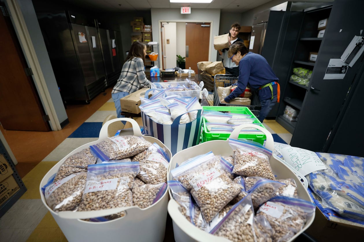 Volunteers with the Latin American Association — including Ellen Goldwasser (left), Nick Nele (center) and Ellen Levitt — are seen organizing boxes and bags of food in 2025. The organization is dedicated to empowering individuals and families through education, workforce development, immigration services and community engagement. (Miguel Martinez/AJC)