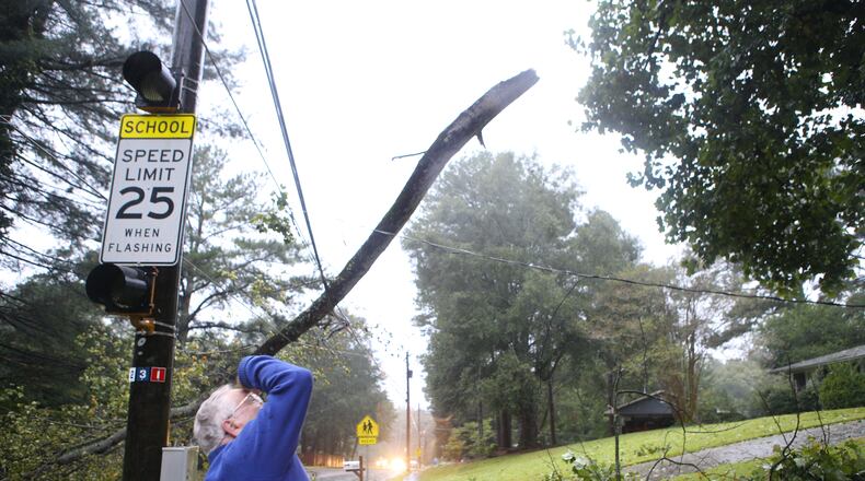 A Dekalb man looks up to find the origin point of a branch that broke off and mangled power lines on Briarcliff Road NE on Monday, September 11, 2017. As tropical storm Irma passes through Georgia, strong winds and gusts take down trees and power lines all across metro Atlanta. (Photo by Henry Taylor/henrytaylorphoto@gmail.com)