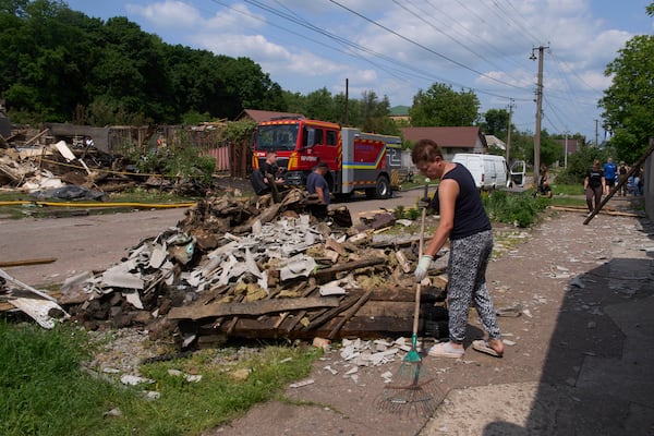 People clear the rubble of residential houses destroyed by a Russian drone strike in Pryluky village, Ukraine, Thursday, June 5, 2025. (AP Photo/Evgeniy Maloletka)