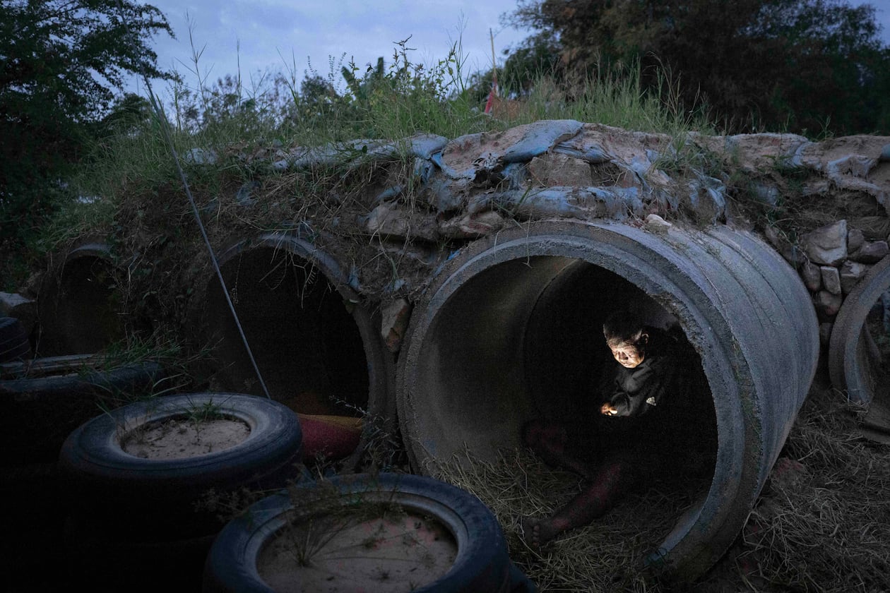 A Thai resident who fled clashes between Thai and Cambodian soldiers, uses mobile phone while taking shelter in Buriram province, Thailand, Tuesday, Dec. 9, 2025. (AP Photo/Wason Wanichakorn)