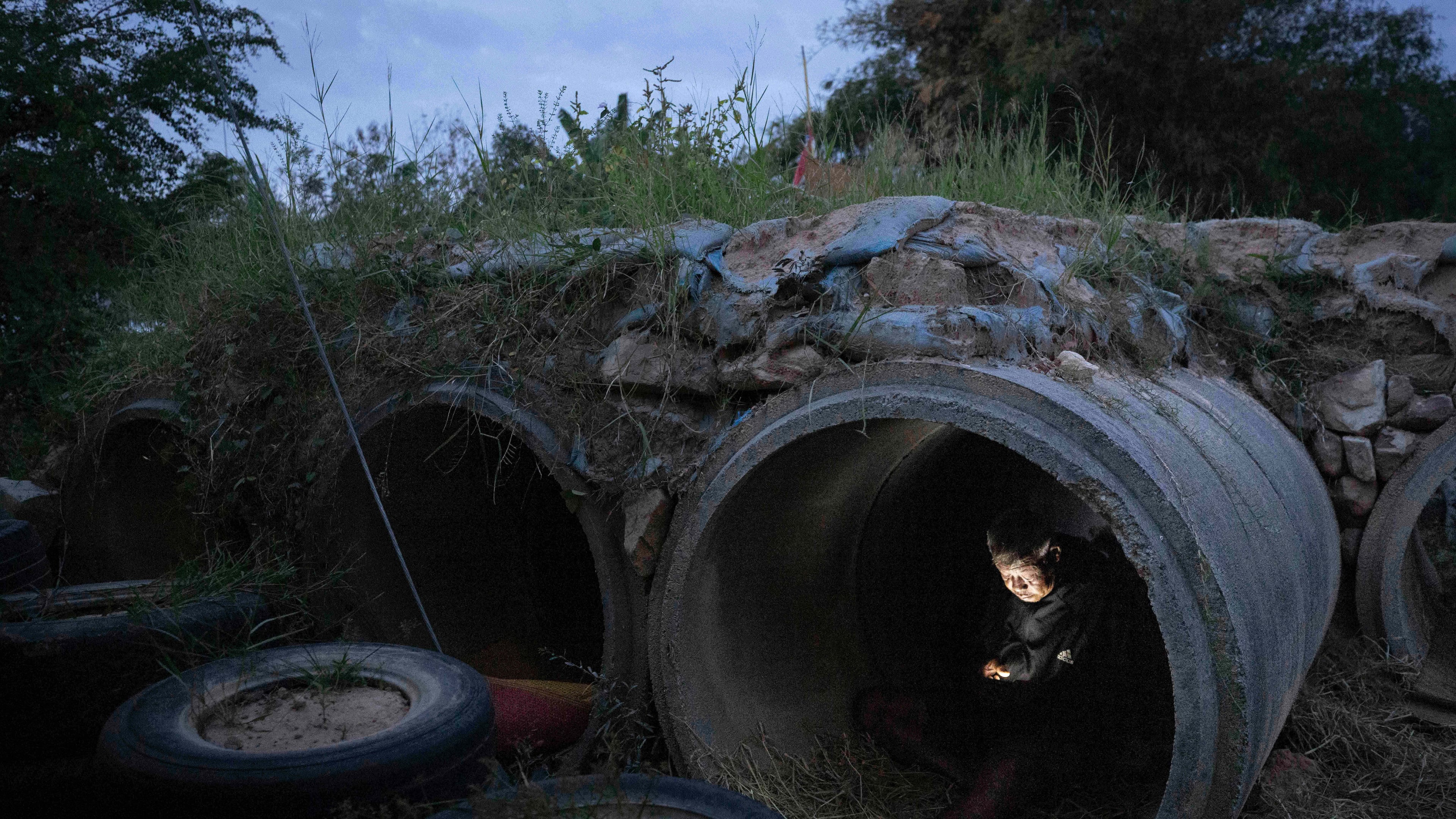 A Thai resident who fled clashes between Thai and Cambodian soldiers, uses mobile phone while taking shelter in Buriram province, Thailand, Tuesday, Dec. 9, 2025. (AP Photo/Wason Wanichakorn)