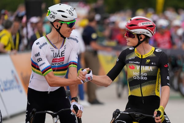 Slovenia's Tadej Pogacar, left, shakes hands with Denmark's Jonas Vingegaard at the start of the first stage of the Tour de France cycling race over 184.9 kilometers (114.9 miles) with start and finish in Lille, France, Saturday, July 5, 2025. (AP Photo/Mosa'ab Elshamy)