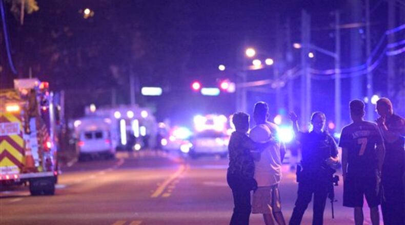 Orlando Police officers direct family members away from a multiple shooting at a nightclub in Orlando, Fla., Sunday, June 12, 2016. (AP Photo/Phelan M. Ebenhack)