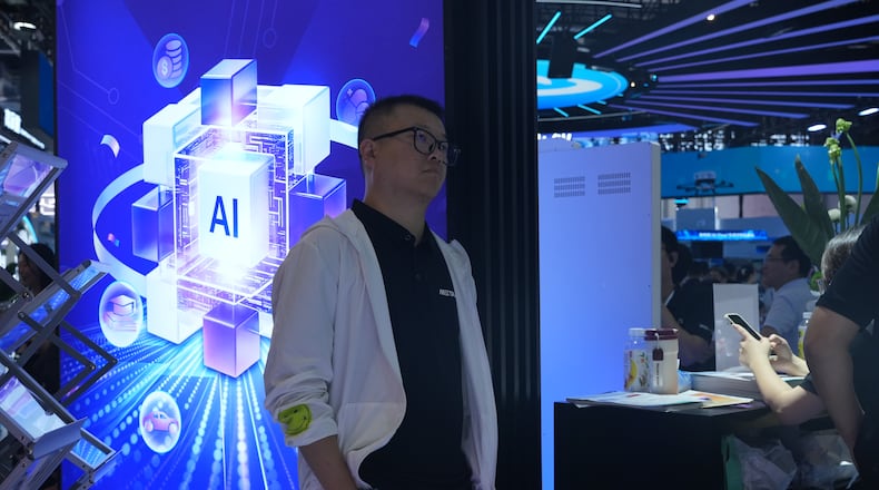 A visitor stands near a display about AI during the World AI Conference in Shanghai, China on July 17, 2026. (AP Photo/Ng Han Guan)
