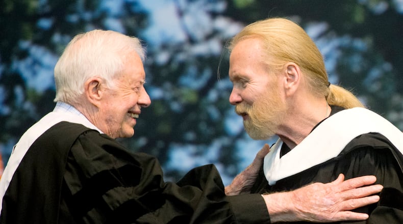 Former President Jimmy Carter and Rock and Roll Hall of Famer Gregg Allman embrace while Allman receives an honorary Doctor of Humanities degree during Mercer University's commencement at Hawkins Arena in Macon, Ga., on Saturday, May 14, 2016. (Jason Vorhees/The Macon Telegraph via AP)