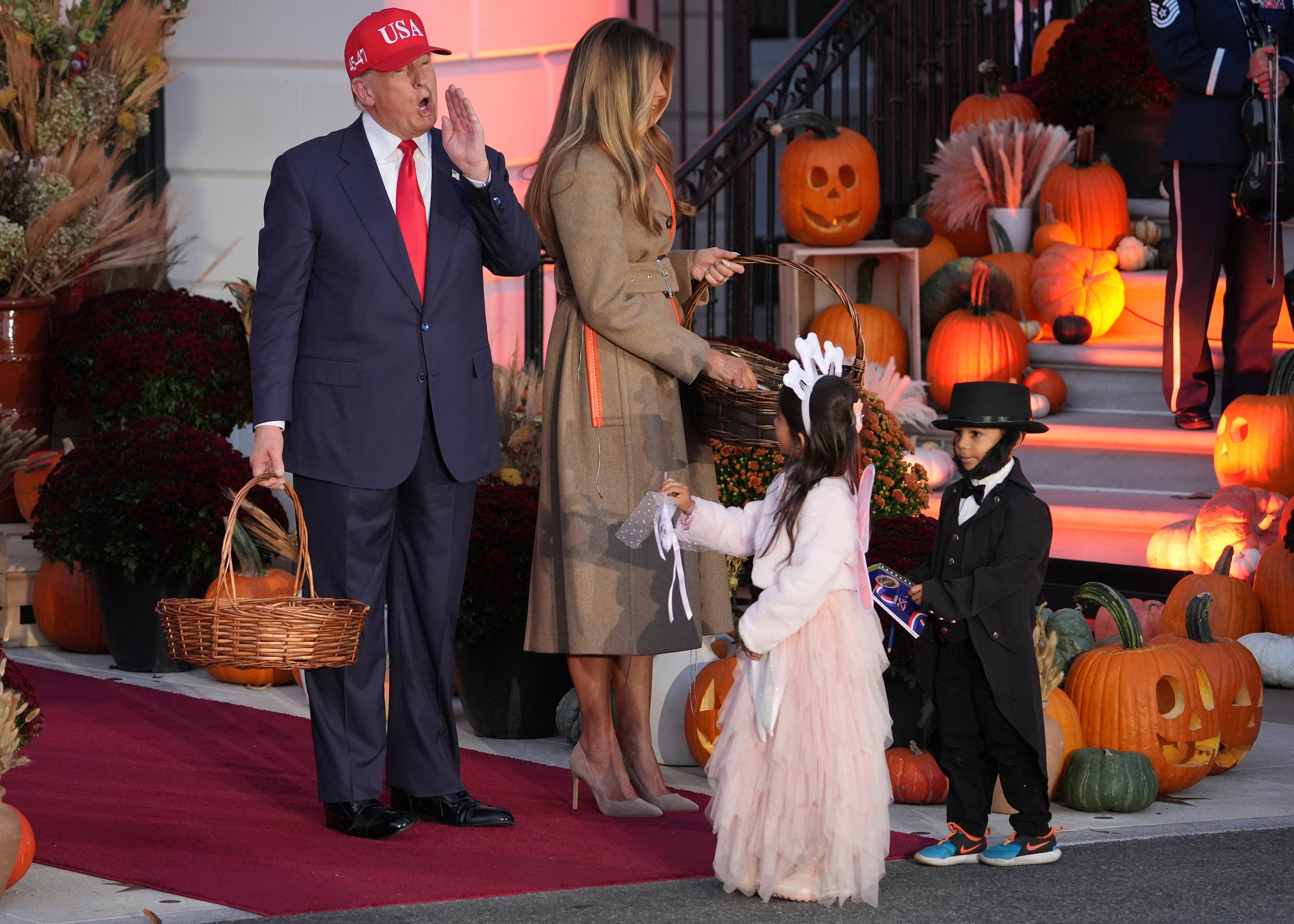 President Donald Trump and first lady Melania Trump handed candy to children dressed as the tooth fairy and Abraham Lincoln during a Halloween event at the White House on Thursday.