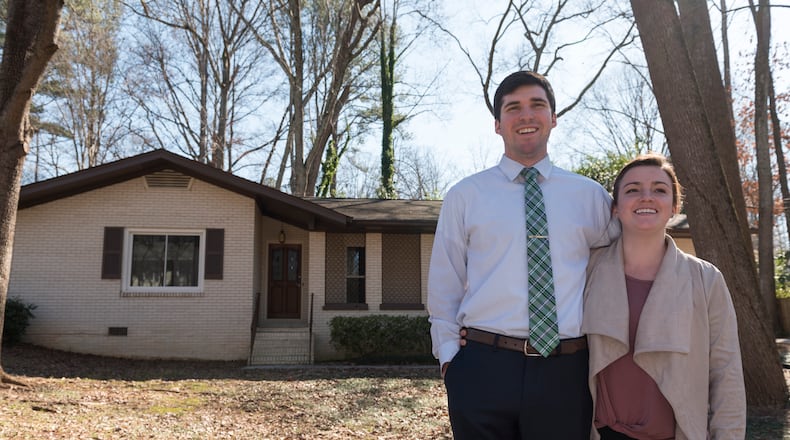 Michael Fox, left, and his wife Erica Fox, right, pose for a portrait outside their home in Decatur, Georgia, on Tuesday, January 31, 2017. The Fox's recently purchased their home within the past year after some difficulty searching the market. Now they are seeing its value rise and are proud of the home they have made. (DAVID BARNES / DAVID.BARNES@AJC.COM)