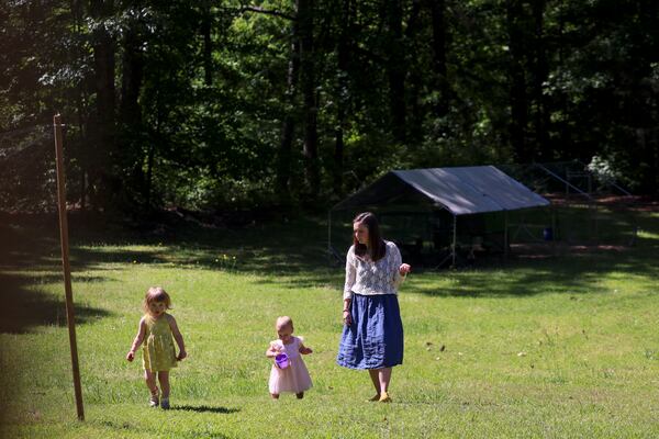 Rachael Maszk and her daughters, Inez, 17 months and Zoe, 2, enjoy their backyard in unincorporated Fayetteville County. (Jason Getz/AJC)
