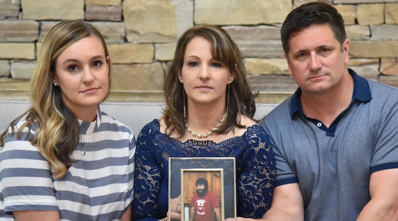 July 25, 2018 Alpharetta - Siblings of Gregg Ivey, who died of a heroin overdose, (from left) Brooke Levenson, Julie Ivey and Joe Ivey hold a photograph of their brother Gregg Ivey at Little River Farms on Wednesday, July 25, 2018. Gregg Ivey who loved music and his dog River passed out, stopped breathing and soon died at North Fulton Hospital of an overdose. His friend, Graham Williams, who injected the drug into Ivey’s vein, has been charged with felony murder, with the underlying felony being distribution of heroin. HYOSUB SHIN / HSHIN@AJC.COM