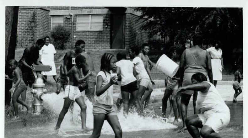 July 1980 -- A gushing fire hydrant helped cool off residents of Atlanta's Perry Homes complex during a midsummer heat wave. CHERYL BRAY / AJC PHOTO ARCHIVES