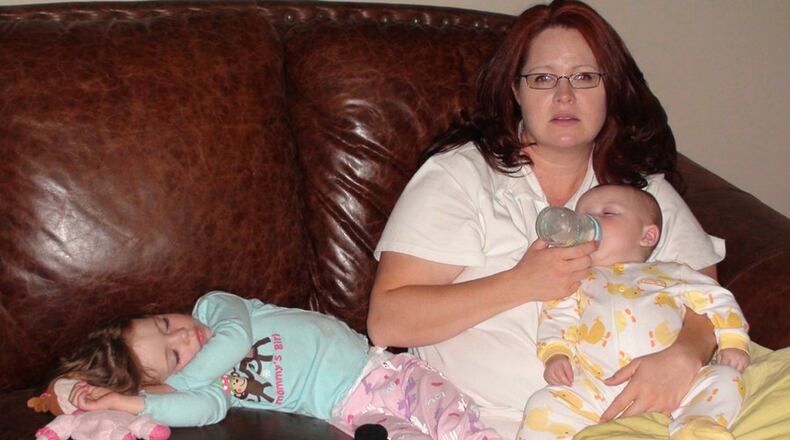 Amy Corn gives her son a bottle while her daughter lies nearby. Corn suffered from postpartum depression after both pregnancies. CONTRIBUTED