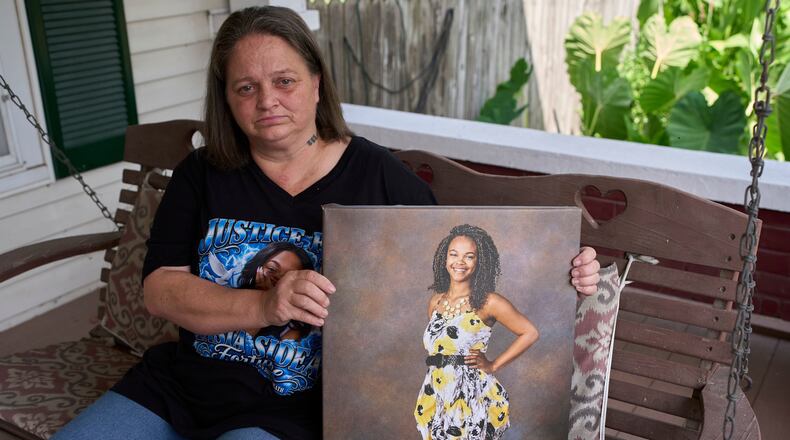Christy Spivey poses with a portrait of her late daughter Tasia Fortune, Tuesday, Sept. 8, 2026, in Marion, Ky. (AP Photo/George Walker IV)