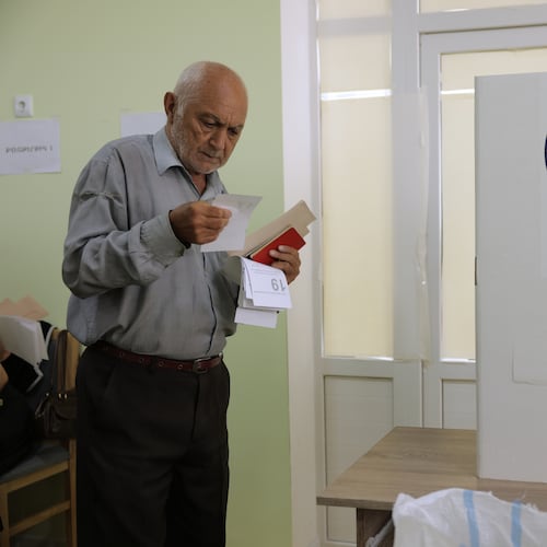A man looks at his ballot at a polling station during the parliamentary election in Yerevan, Armenia, Sunday, June 7, 2026. (AP Photo/Anthony Pizzoferrato)