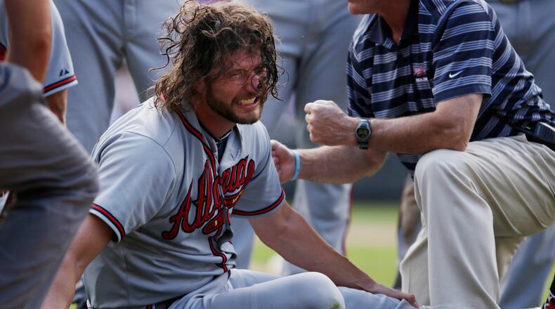 Atlanta Braves relief pitcher Jason Grilli reacts to an injury to his left leg while running to cover first base during the ninth inning of a baseball game against the Colorado Rockies in Denver on Saturday, July 11, 2015. Grilli left game and was taken from the field on a medical cart. (AP Photo/Joe Mahoney)