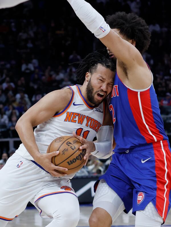 New York Knicks guard Jalen Brunson (11) collides with Detroit Pistons guard Cade Cunningham while going to the basket during the first half of an NBA basketball game Thursday, April 10, 2025, in Detroit. (AP Photo/Duane Burleson)