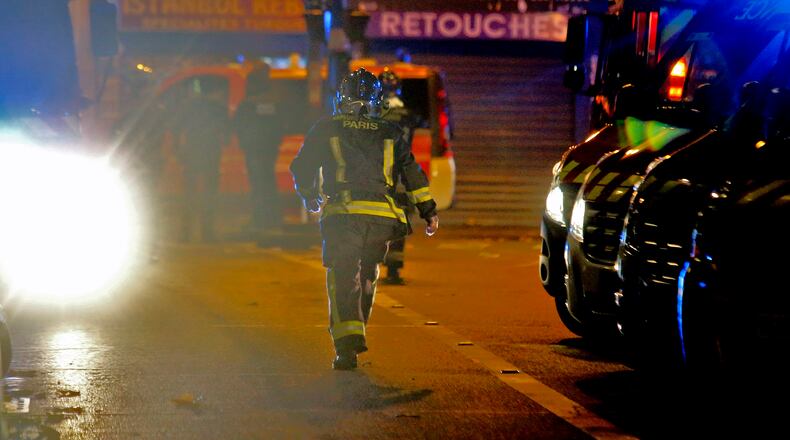 A rescue worker runs after an explosion in the 10th district of Paris, Friday, Nov. 13, 2015. Several dozen people were killed Friday in a series of terror attacks, the deadliest to hit Paris since World War II, French President Francois Hollande said, announcing that he was closing the country's borders and declaring a state of emergency. (AP Photo/Jacques Brinon)