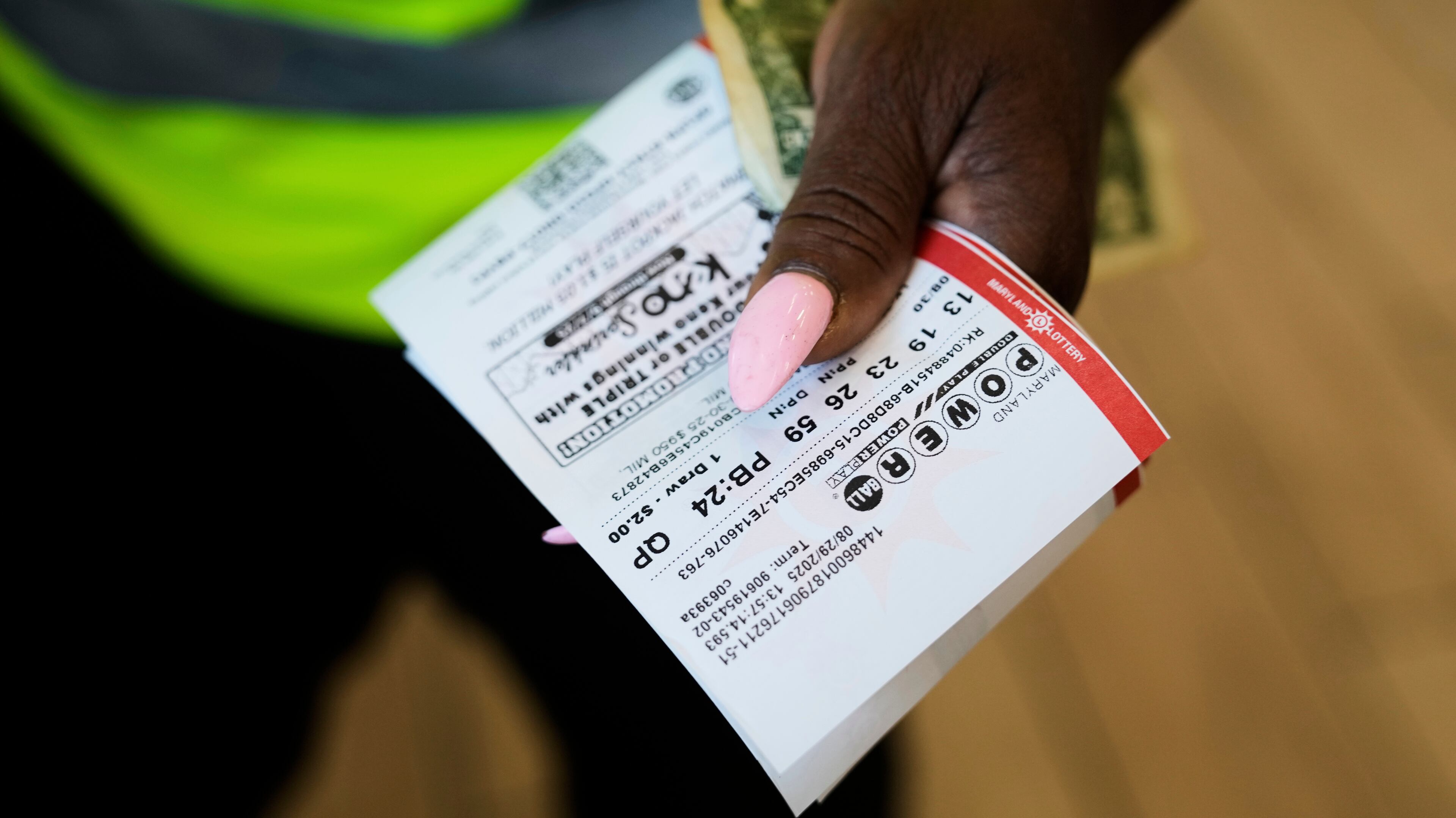 Roslyn Jefferson holds her Powerball lottery tickets ahead of Saturday's Powerball drawing offering of $1 billion, Friday, Aug. 29, 2025, in Baltimore. (AP Photo/Stephanie Scarbrough)
