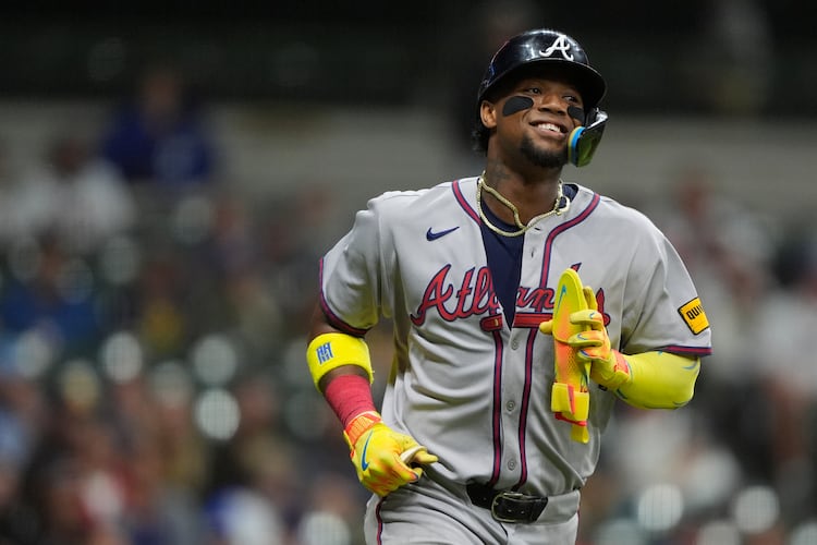 Atlanta Braves' Ronald Acuña Jr. smiles as he jogs to first base after drawing a walk during the ninth inning of a baseball game against the Milwaukee Brewers, Monday, June 9, 2025, in Milwaukee. (AP Photo/Aaron Gash)