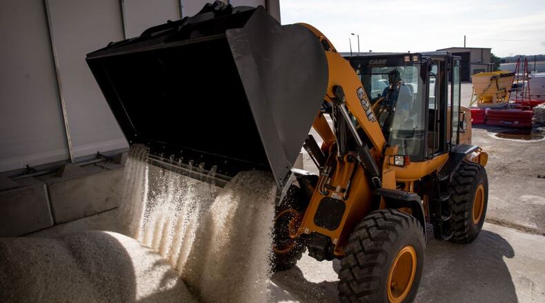Roderick Browning pours salt into a salt barn at GDOT’s maintenance activities center where workers are preparing for possible snow this weekend, Thursday in Forest Park. BRANDEN CAMP/SPECIAL
