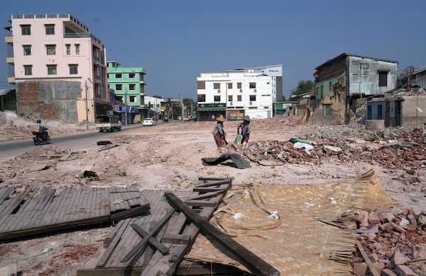 Volunteers help to clear collapsed buildings after one month of the strong earthquake in Naypyitaw, Myanmar, Monday, April 28, 2025. (AP Photo/Aung Shine Oo)