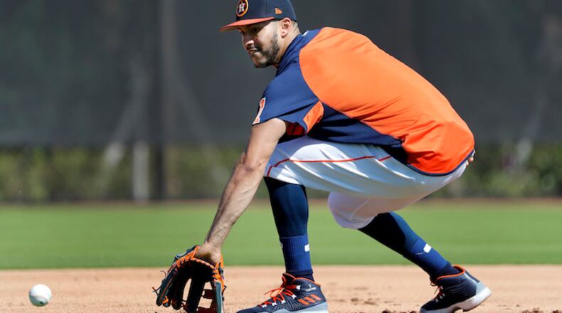Houston Astros infielder Carlos Correa handles a grounder during spring training baseball practice Monday, Feb. 19, 2018, in West Palm Beach, Fla. (AP Photo/Jeff Roberson)