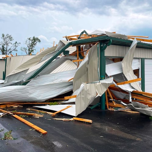 In this photo provided by Christian Jensen, twisted metal and wooden planks from a building damaged by a severe storm litter the pavement, Monday, July 27, 2026, in Menasha, Wis. (Christian Jensen via AP)