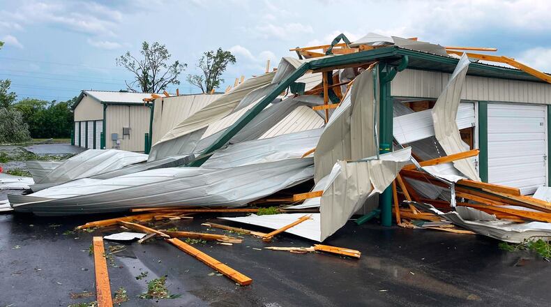 In this photo provided by Christian Jensen, twisted metal and wooden planks from a building damaged by a severe storm litter the pavement, Monday, July 27, 2026, in Menasha, Wis. (Christian Jensen via AP)