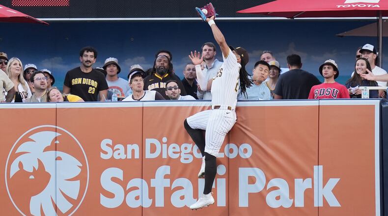 San Diego Padres right fielder Fernando Tatis Jr. makes the catch above the wall for the out on a sacrifice fly by San Francisco Giants' Rafael Devers during the first inning of a baseball game Thursday, July 30, 2026, in San Diego. (AP Photo/Gregory Bull)