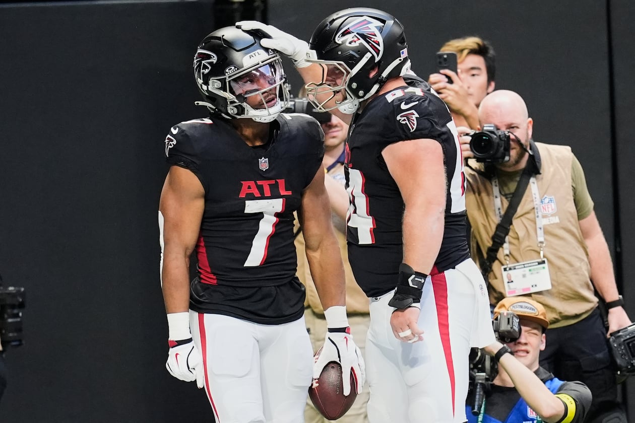 Atlanta Falcons running back Bijan Robinson (7) celebrates his touchdown with guard Ryan Neuzil (64) in the first half of an NFL football game against the Carolina Panthers, Sunday, Nov. 16, 2025, in Atlanta. (AP Photo/Mike Stewart)
