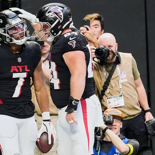 Atlanta Falcons running back Bijan Robinson (7) celebrates his touchdown with guard Ryan Neuzil (64) in the first half of an NFL football game against the Carolina Panthers, Sunday, Nov. 16, 2025, in Atlanta. (AP Photo/Mike Stewart)